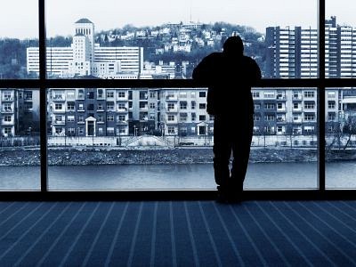 339454-man-waiting--looking-out-window-at-city-buildings-and-river.jpg